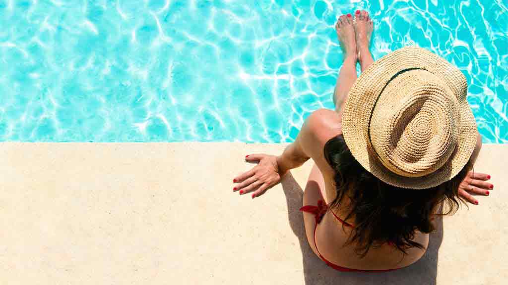 woman sits by pool