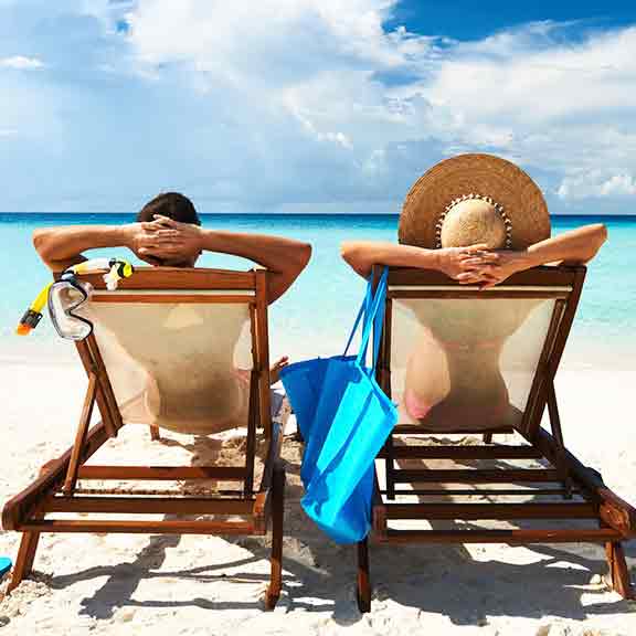 couple relaxing in lounge chairs on a beach square