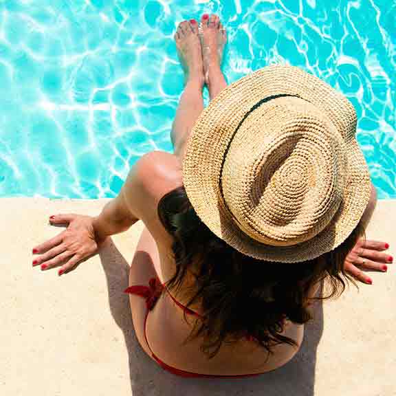 woman sits by pool square