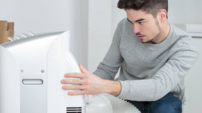 man using a portable air conditioner at home