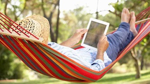 person using tablet on hammock