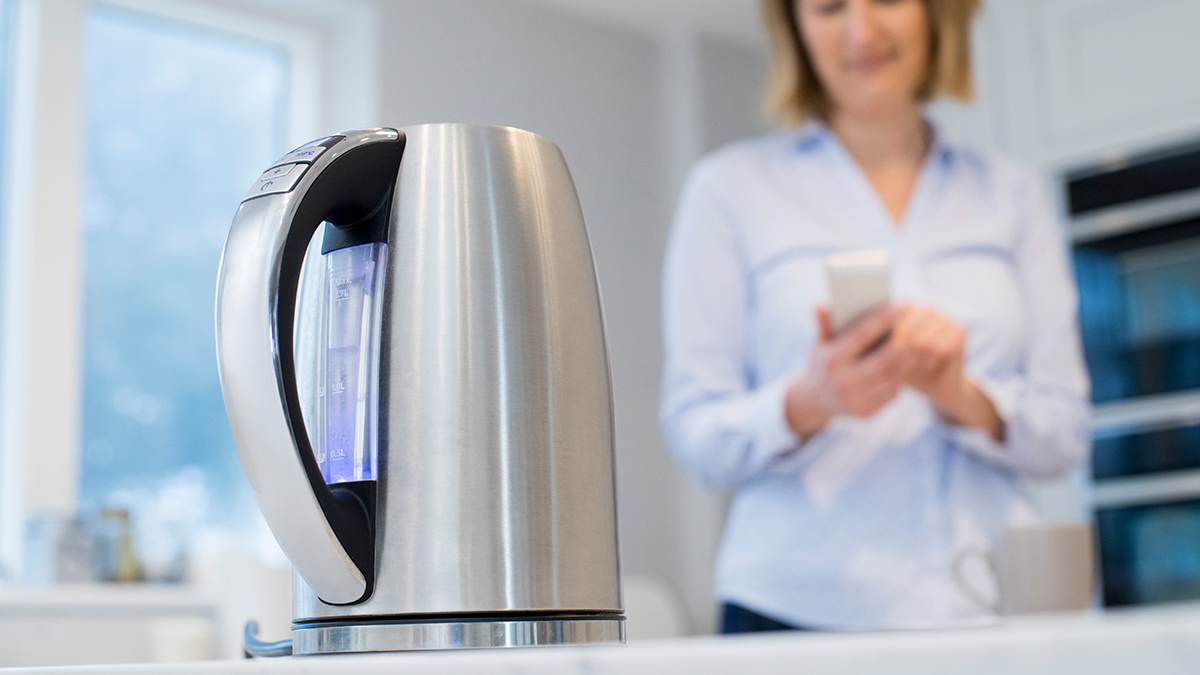 woman using kettle in kitchen