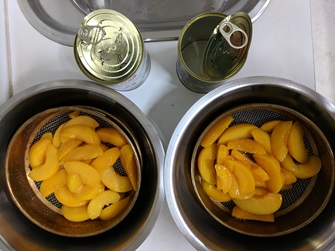 canned peaches draining in sieve