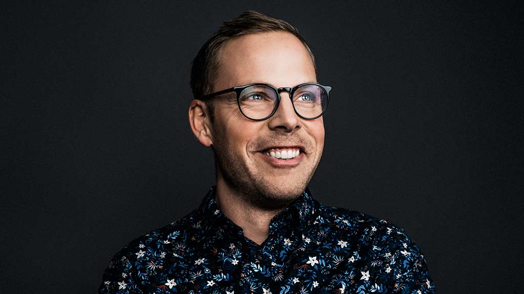 young man wearing glasses smiling