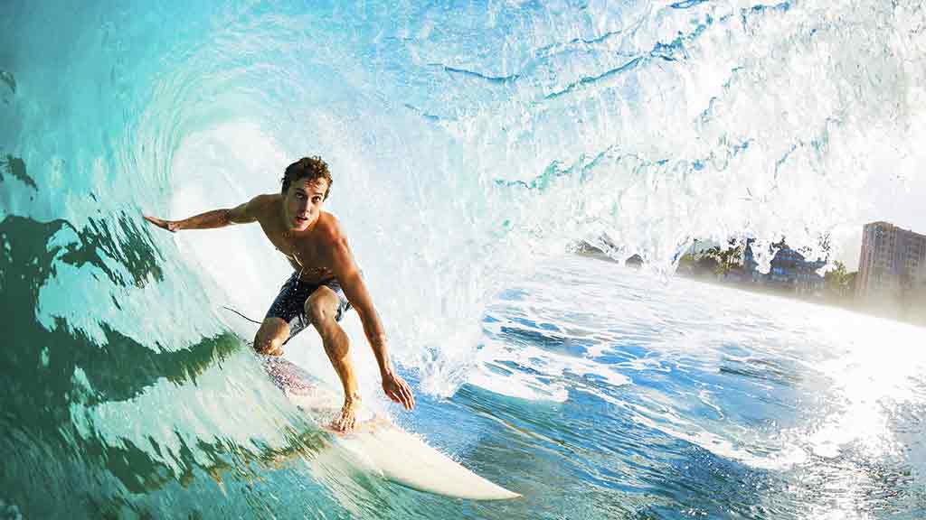 surfer catches wave