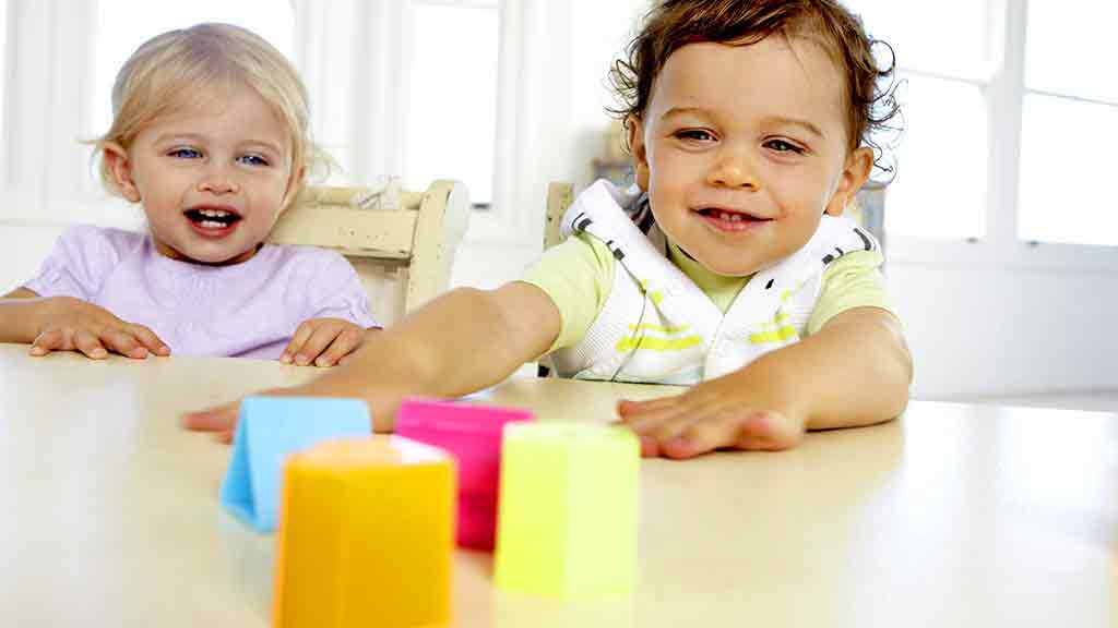toddlers playing with coloured blocks
