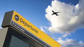 plane flying over departures sign