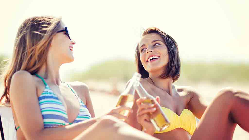 woman on the beach drinking alcohol