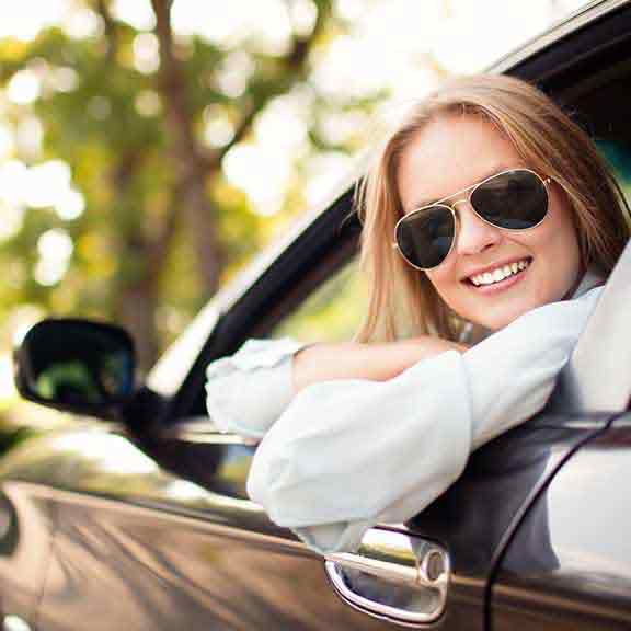 woman in sunglasses looking out car window square
