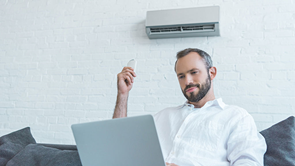 man using air conditioner at home