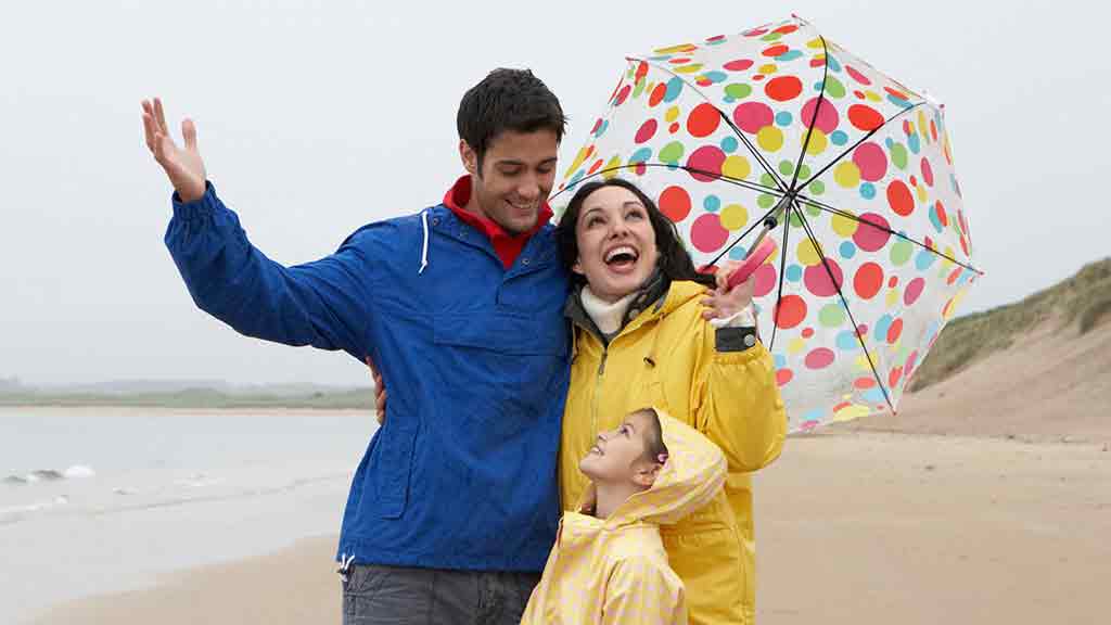 family on the beach in the rain