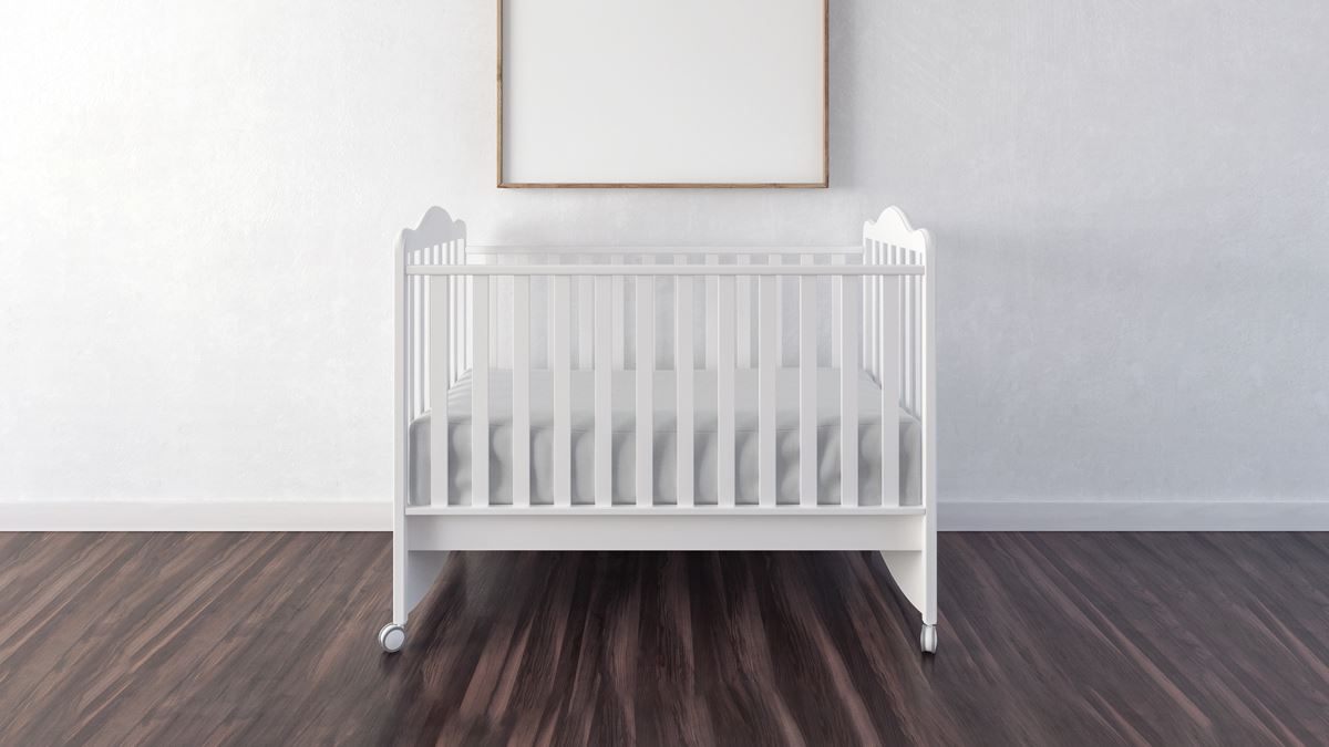 white cot on wooden floor