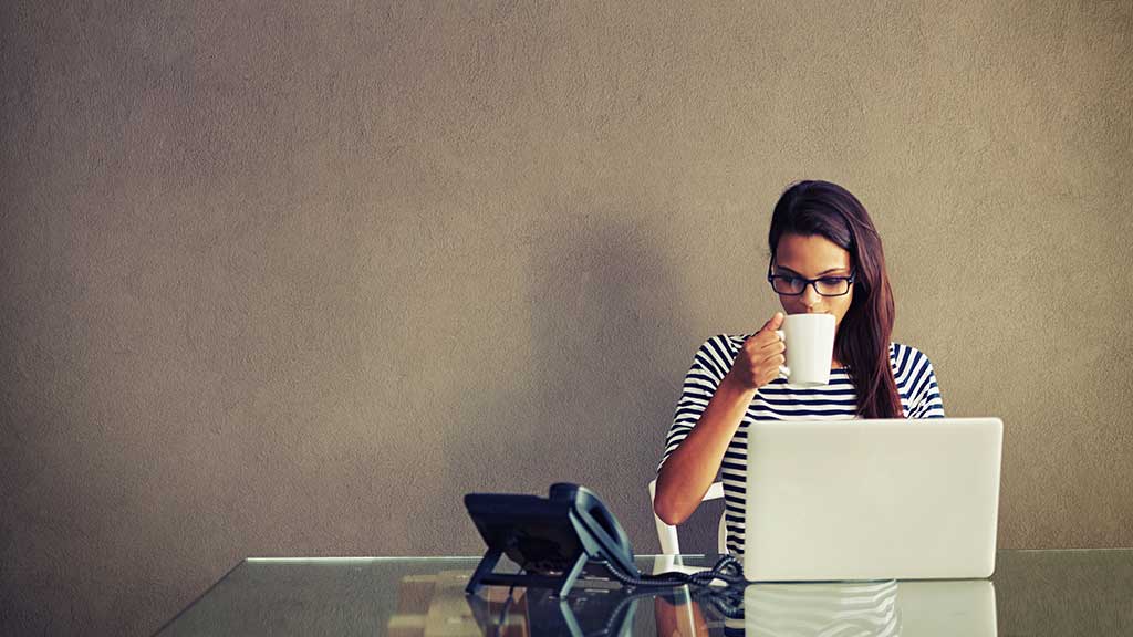 woman on computer having coffee