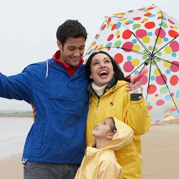 family on the beach in the rain square