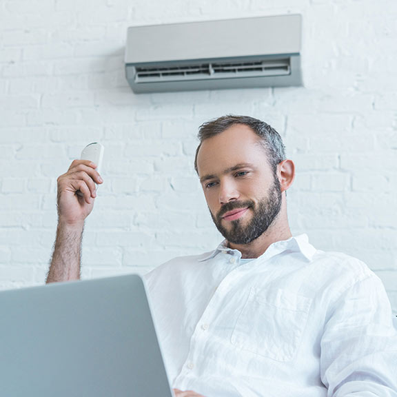 man using air conditioner at home sq