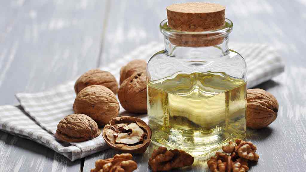 nuts and oil in a jar with tea towel