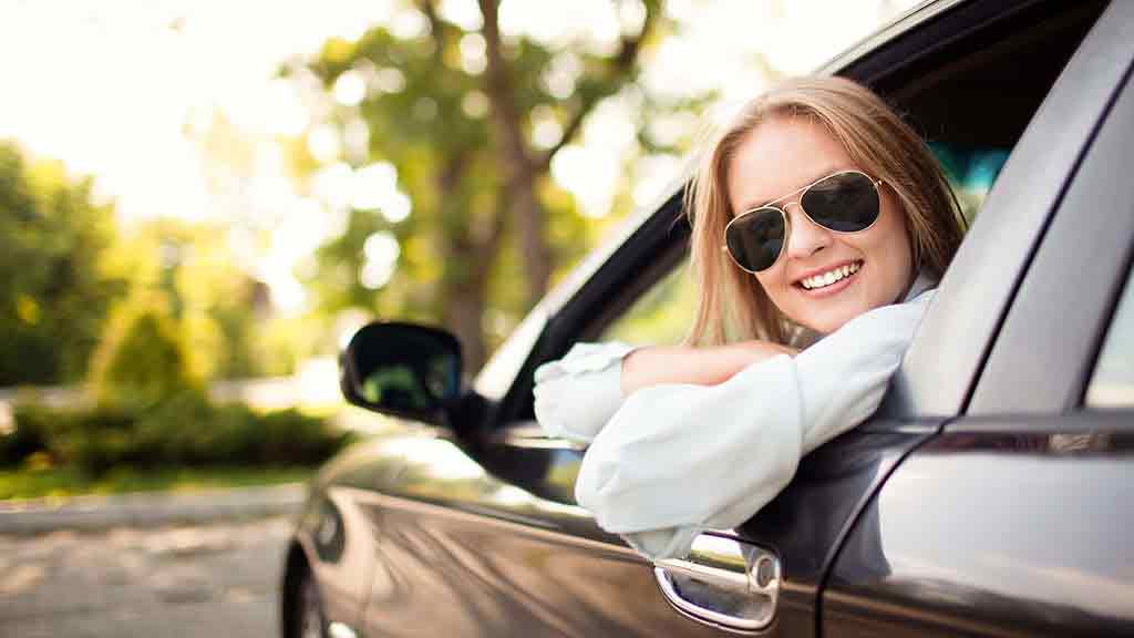 woman in sunglasses looking out car window