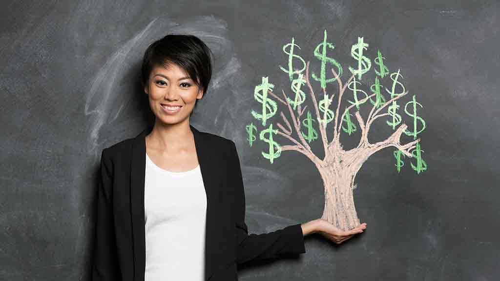 woman holds tree with money growing on it