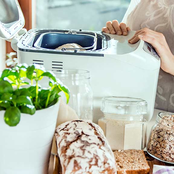 woman using bread maker at home sq