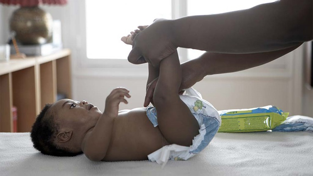person putting a nappy on a baby