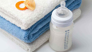a baby bottle with a stack of towels