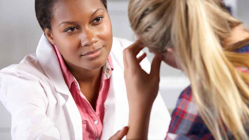 doctor in white coat counsels distressed woman