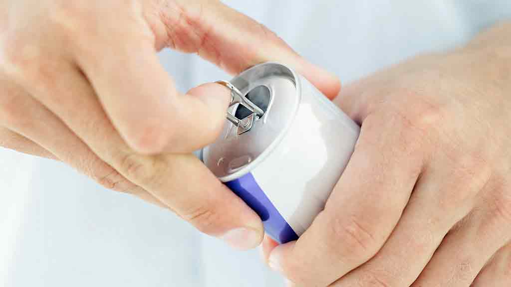 opening a can of red bull energy drink