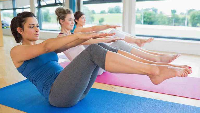 women exercising on gym mats