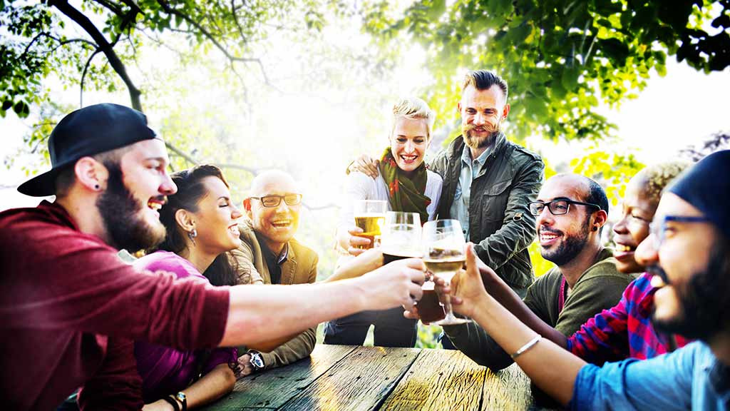 friends drinking socially in park