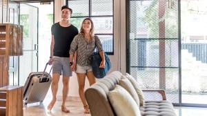 asian couple with suitcases entering property