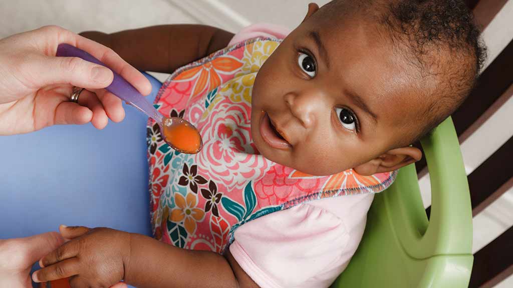 baby in portable baby seat on chair