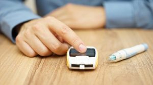 person with finger on blood glucose meter