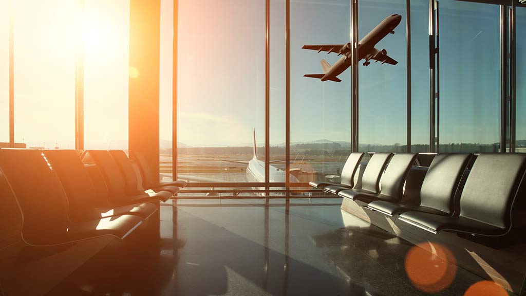 view out airport window of plane taking off