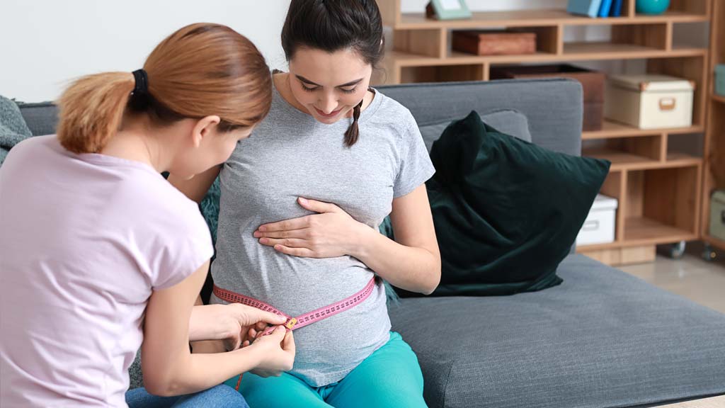 Doula measuring pregnant stomach