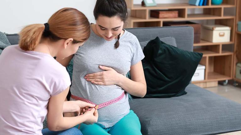 Doula measuring pregnant stomach
