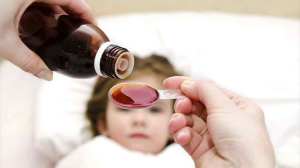 child receiving painkiller syrup