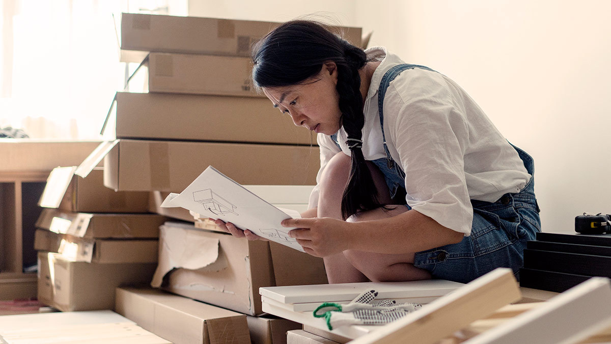 person looking at instructions to assemble set of drawers for nursery