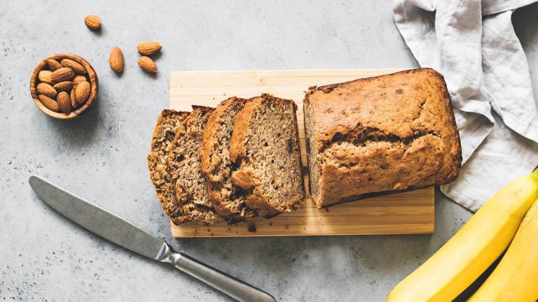 homemade banana bread on bench with bananas