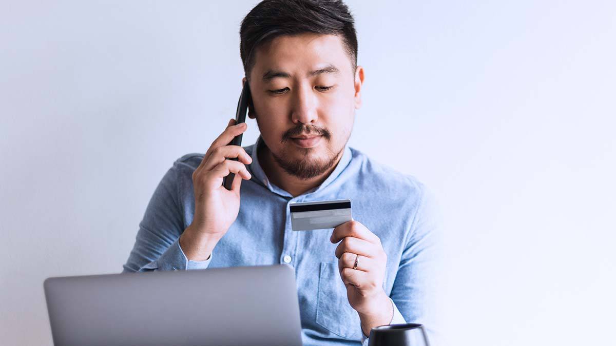person on phone and checking their credit card number