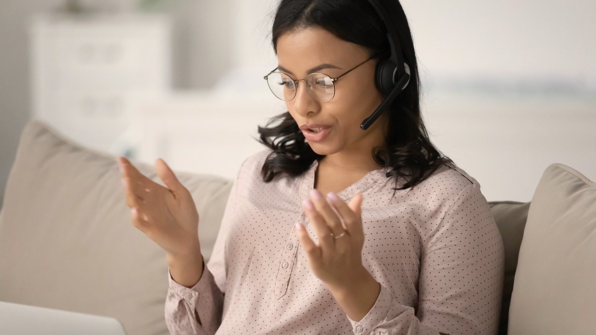 Woman using headset to speak on a laptop