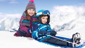 two children playing with a toboggan
