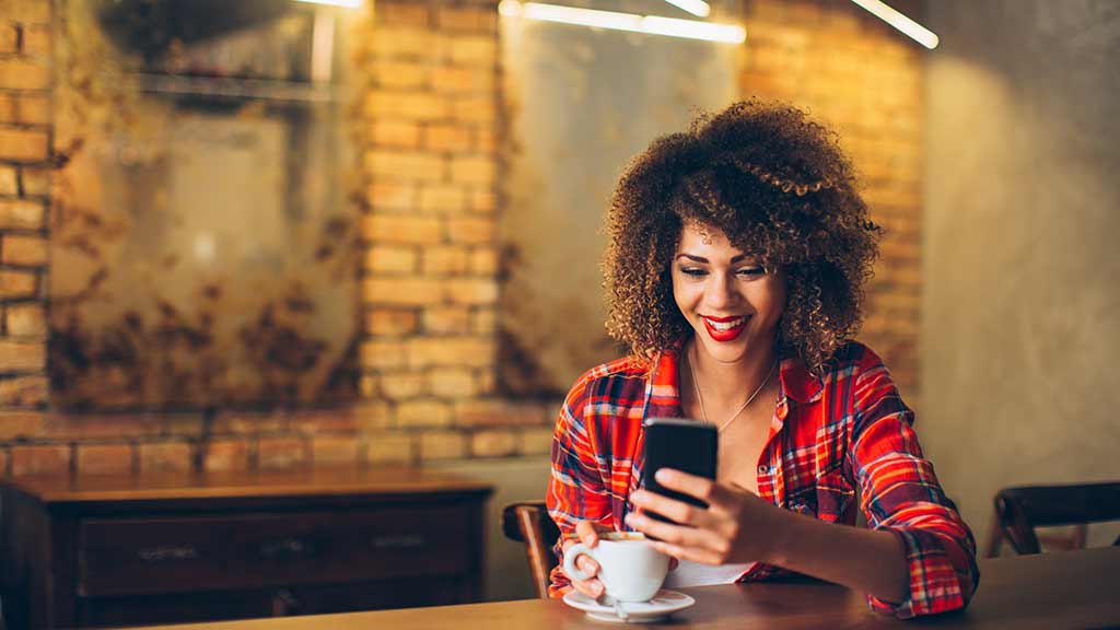 woman in cafe texting on phone