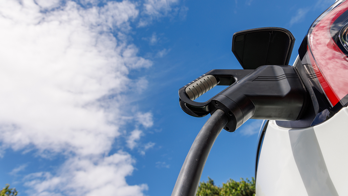 charger_connected_to_an_electric_car_against_a_blue_sky