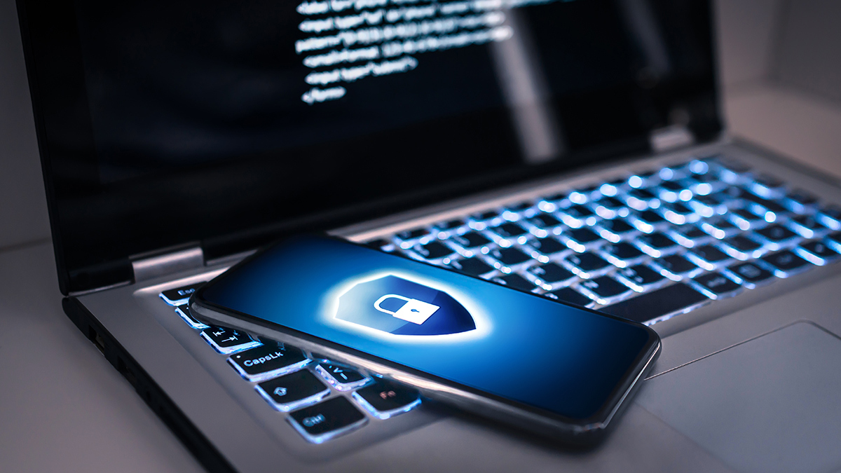 laptop and smartphone with security shield on screen