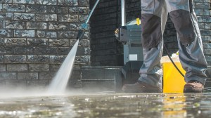 person_testing_pressure_washer_on_driveway