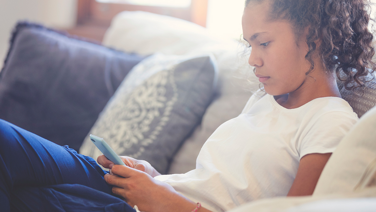 australian_teenager_using_smartphone_on_sofa