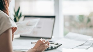 person_processing_figures_on_a_form_using_a_calculator