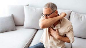 man coughing at home