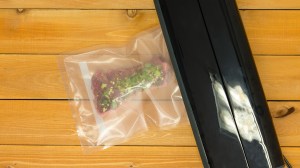vacuum sealer sealing meat on a wooden board