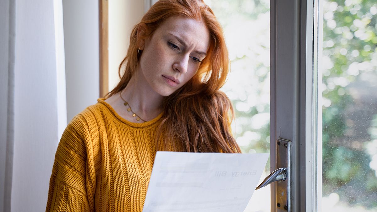 concerned person looking at energy bill at home